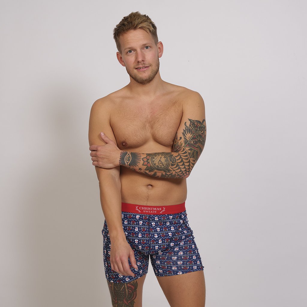 En man klädd i blå kalsonger med julmotiv.